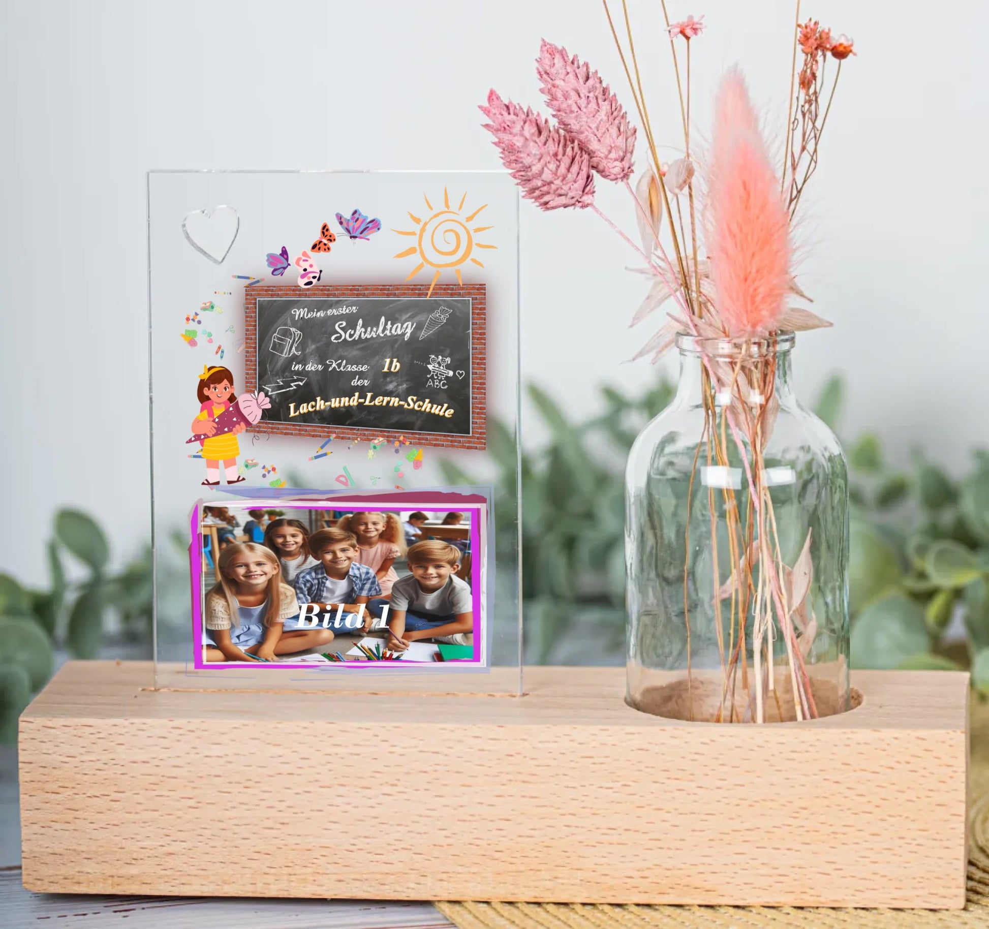 fotoaufsteller-aus-acrylglas-8x11,5cm-personalisiert-mit-foto-und-name-der-schule-mit-kleiner-vase-mit-trockenblumen-auf-einem-hellen-echtholz-sockel-bild-eigt-eine-nahaufnahme