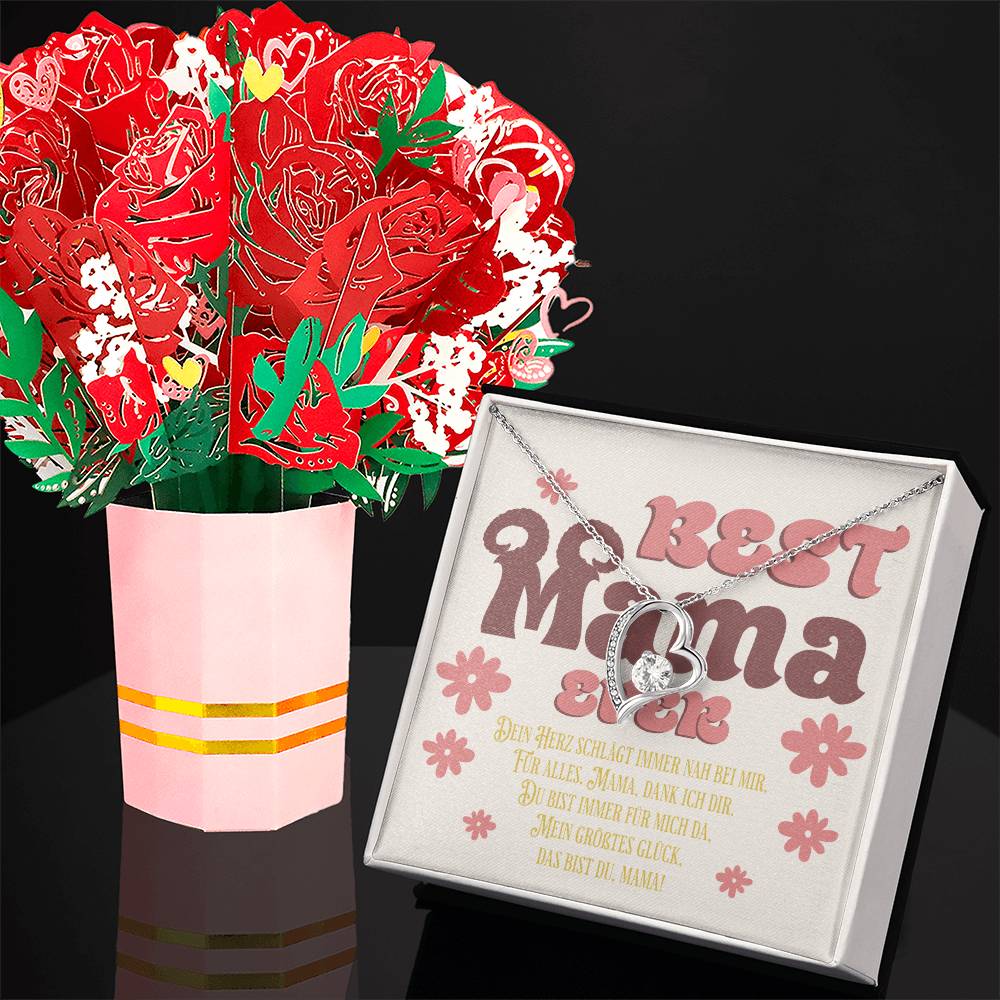 halskette-mit-herzanhänger-und-zirkonia-mit-weißold-finish-in-einer-geschenkbox-mit-grußkarte-best-mama-ever-neben-einem-karton-blumenstrauss