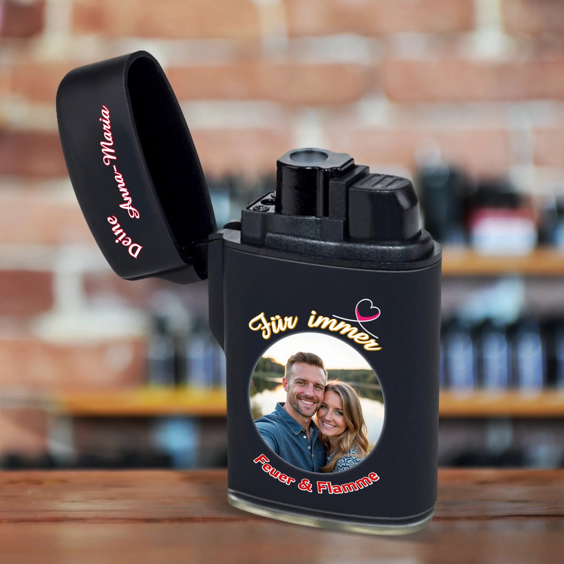jetflame-feuerzeug-schwarz-aufgeklappt-weihnachtsgeschenk-freund-mit-foto-und-name-personalisiert-plus-aufschrift-in-weiss-rot-für-immer-feuer-und-flamme-feuerzeug-steht-auf-rustikaler-tischplatte