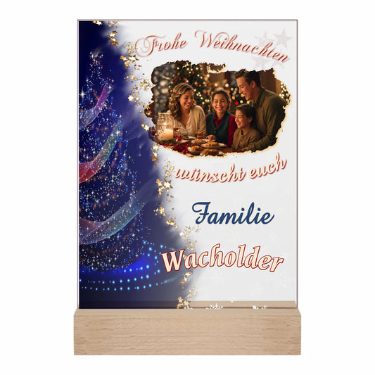 acrylglas-15x20cm-mit-standfuß-aus-echtholz-personalisiert-mit-familienfoto-und-familienname-in -der-linken-haelfte-ist-ein-weihnachtsbaum-mit-bunten-lichtern-und-dunkelblauem-hintergrund-fließender-uebergang-zur-transparentnen-hälfte-mit-foto-name-und-schriftzug-frohe-weihnachten-wuenscht-euch-familie-name-der-familie