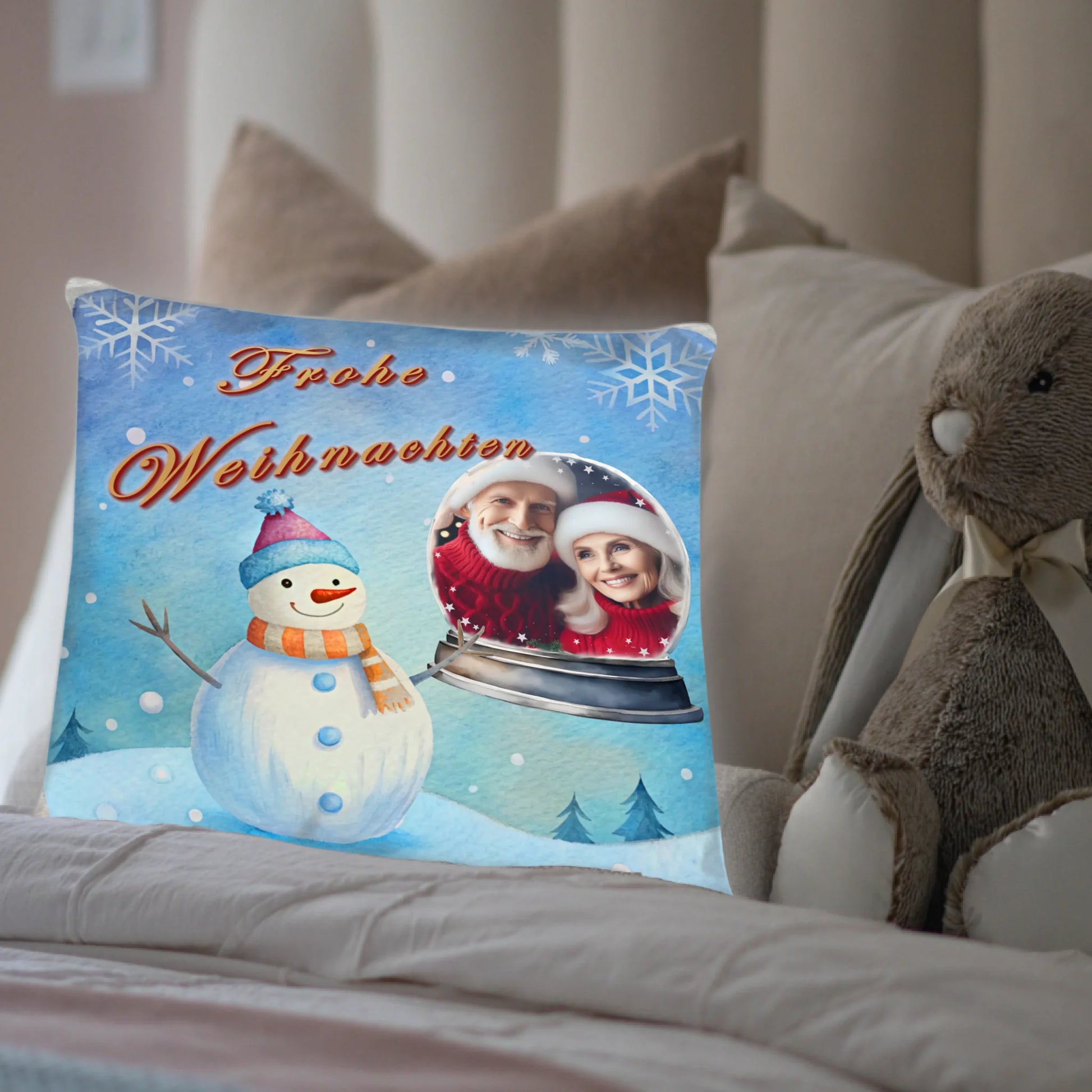kissen-40x40-cm-mit-foto-geschenk-freundin-vorderseite-mit-winterlandschaft-in-hellblau-und-schneemann-daneben-das-foto-in-einer-schneekugel-kissen-steht-in-einem-bett-neben-einem-kuscheltier
