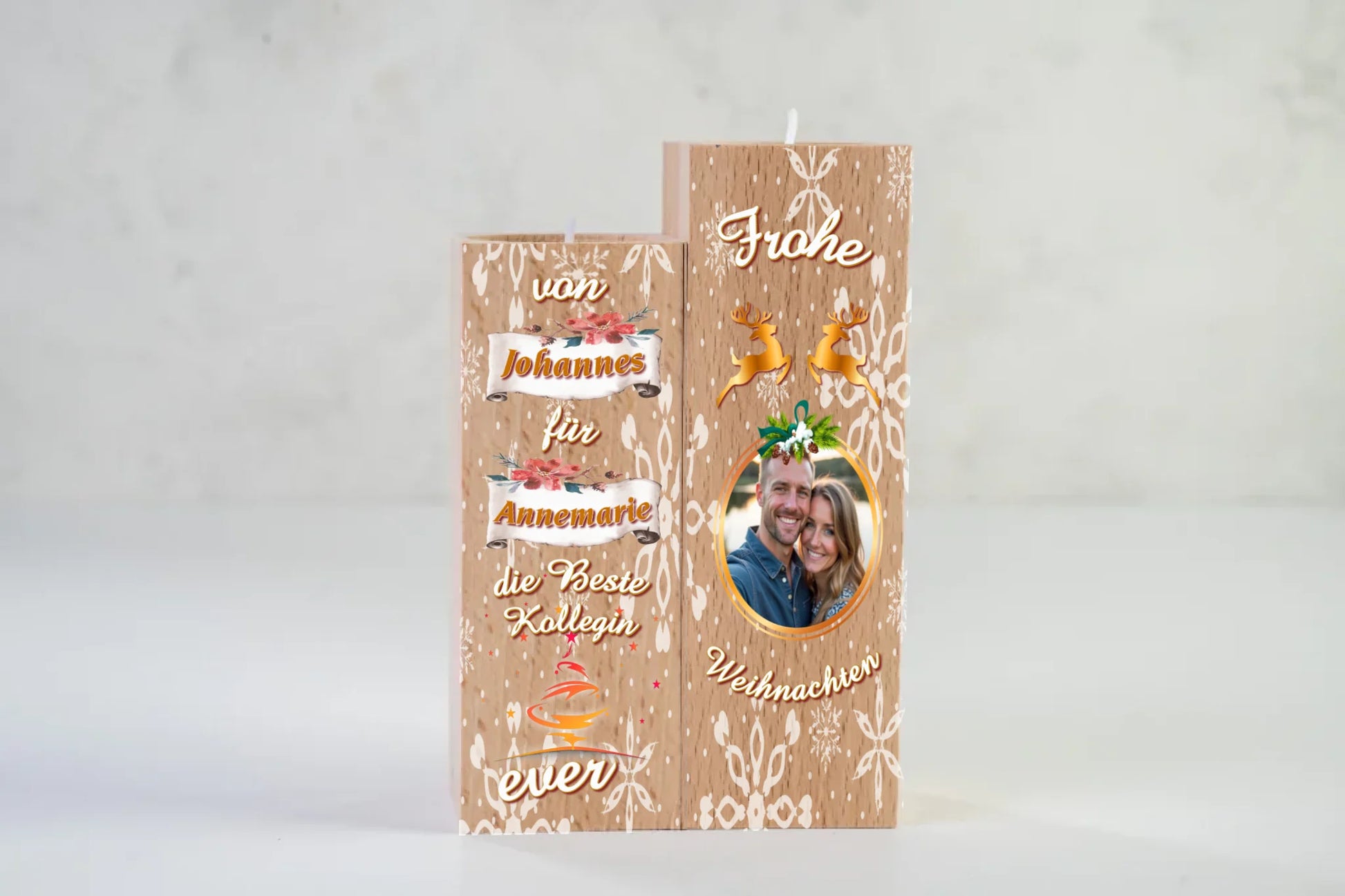 teelichthalter-massiv-holz-2er-set-4,5x4,5cm-12-und-14cm-hoch-personalisiert-mit-foto-und-zwei-namen-weihnachtliches-design-kerzenhalter-rechts-mit-schneeflocken-2-rentier-umrissen-in-gold-ueber-dem-foto-mit-ovalem-goldenem-rahmen-ganz-oben-steht-frohe-und-ganz-unten-steht-weihnachten-design-kerzenhalter-links-schriftzug-von-persnalisierter-name-auf-schriftrolle-fuer-personalisierter-name-die-beste-kollegin-ever-teelichthalter-steht-vor-neutralem-hintergrund