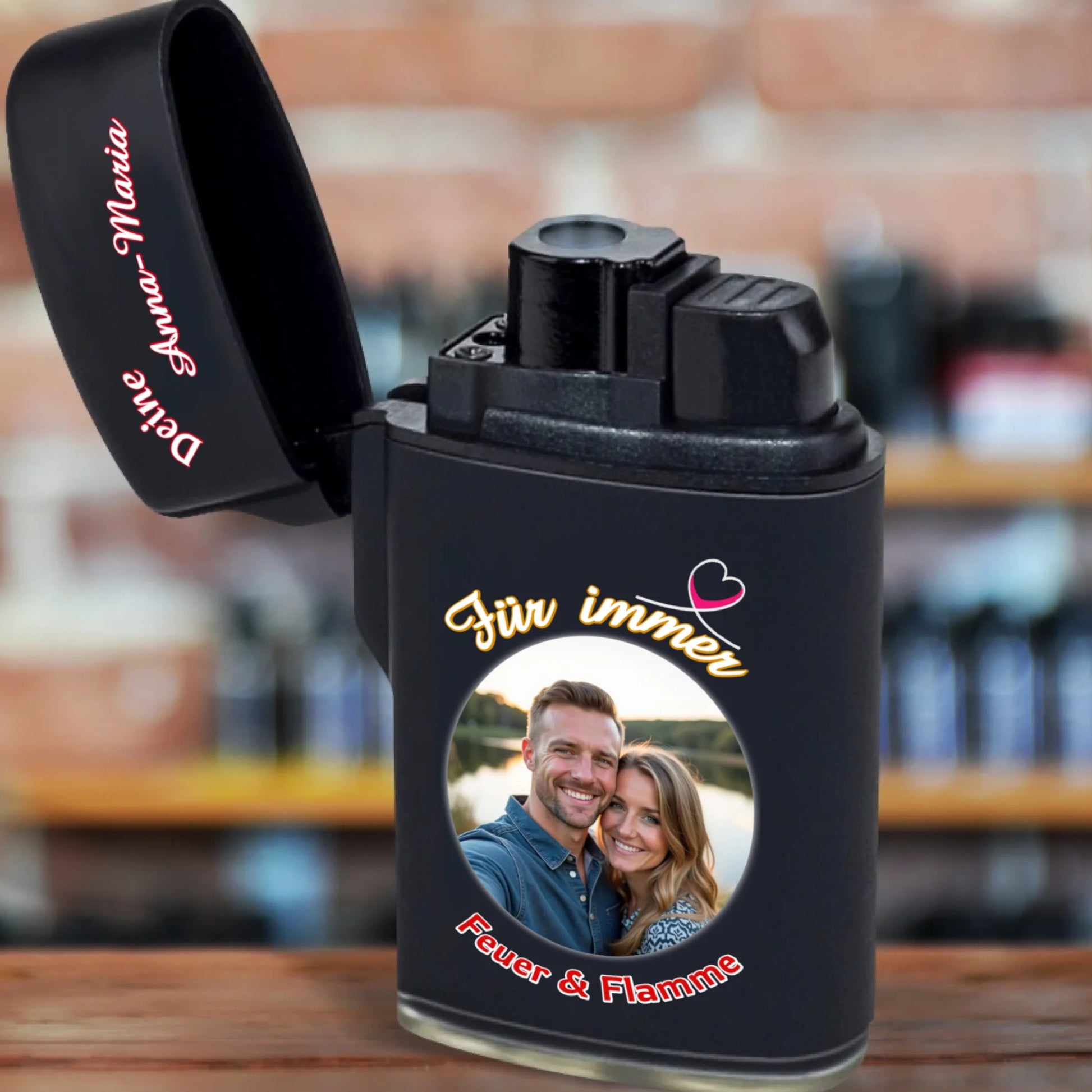 jetflame-feuerzeug-schwarz-aufgeklappt-weihnachtsgeschenk-mann-mit-foto-und-name-personalisiert-plus-aufschrift-in-weiss-rot-für-immer-feuer-und-flamme-feuerzeug-steht-auf-rustikaler-tischplatte