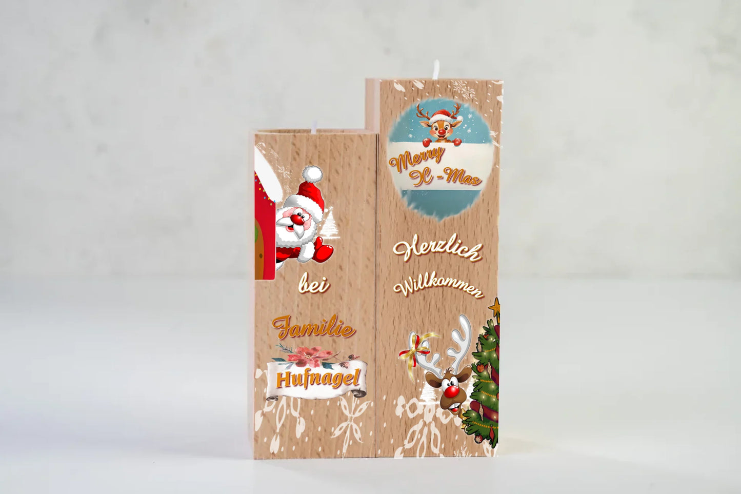 teelichthalter-massiv-holz-2er-set-4,5x4,5cm-12-und-14cm-hoch-personalisiert-mit-familiennamen-weihnachtliches-design-im-comic-style-kerzenhalter-rechts-mit-schneeflocken-oben-ein-rentier-mit-banner-und-schriftzug-merry-x-mas-darunter-schriftzug-herzlich-willkommen-und-ganz-unten-ein-lustiges-rentier-schaut-hinter-weihnachtsbaum-hervor-kerzenhalter-links-oben-winkt-ein-weihnachtsmann-darunter-der schriftzug-bei-familie-personalisierter-familienname-teelichthalter-auf-neutralem-weissen-hintergrund