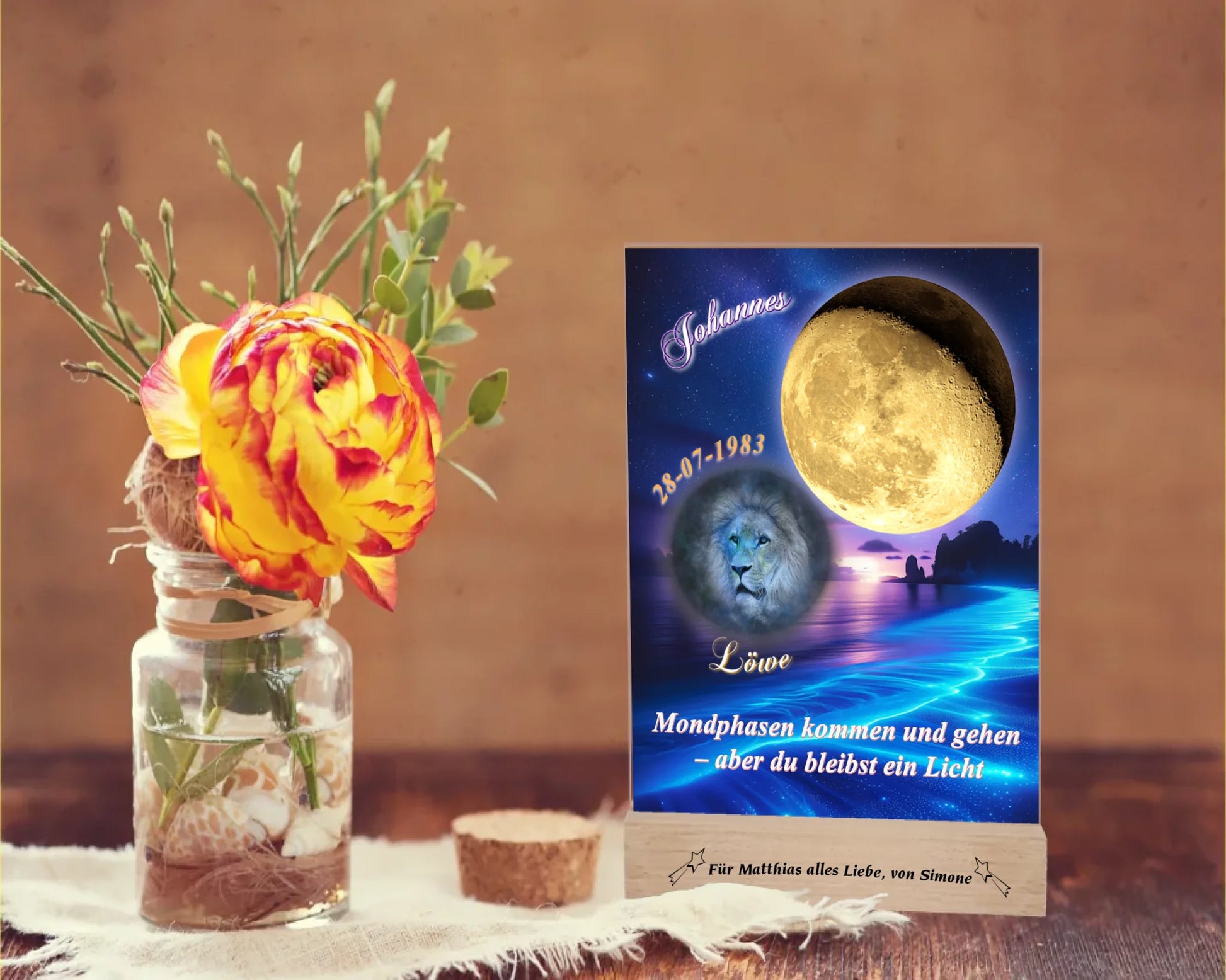 acrylglas-15x20cm-mit-graviertem-holzsockel-design-mit-personalisierter-mondphase-nach-datum-mit-sternzeichen-und-name-kurzer-spruch-monphasen-kommen-und-gehen-aber-du-bleibst-ein-licht-designhintergrund-brandung-meer-in-neon-blau-sternzeichen-ist-hellblau-dargestellt-und-der-mond-golden-acrylglas-steht-auf-rustikalem-holztisch-neben-einer-rose