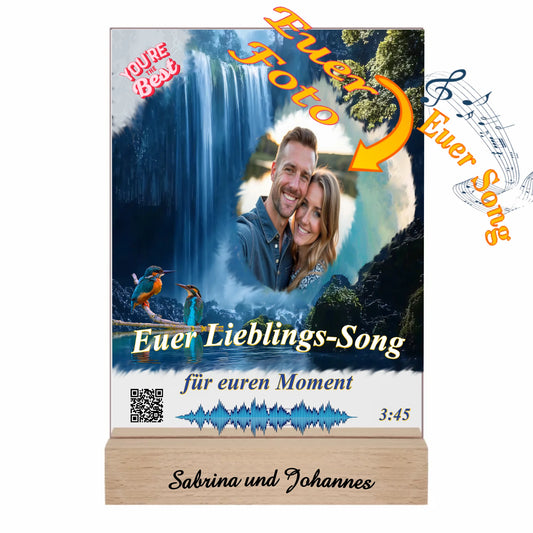 acrylaufsteller-15x20cm-personalisiert-mit-foto-titel-und-interpret-des-ausgewählten-songs-mit-qr-code-und-gravierten-namen-am-holzsockel-design-hintergrund-ein-wasserfall-in-strahlendem-blau-fotoaufsteller-mit-hinweis-zu-personalisierung