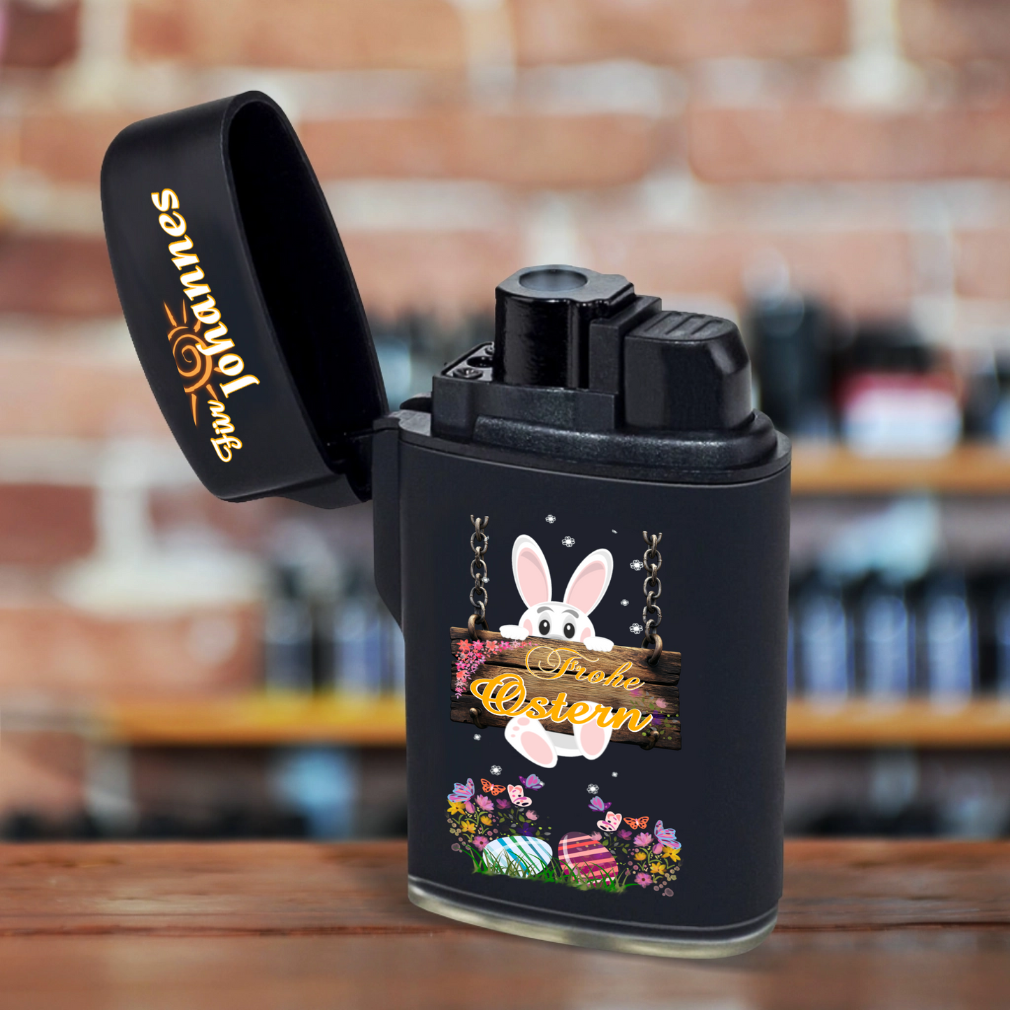 feuerzeug-schwarz-mit-namen-personalisiert-und-motiv-osterhase-hängt-an-einem-holzschild-auf-rustikalem-holztisch