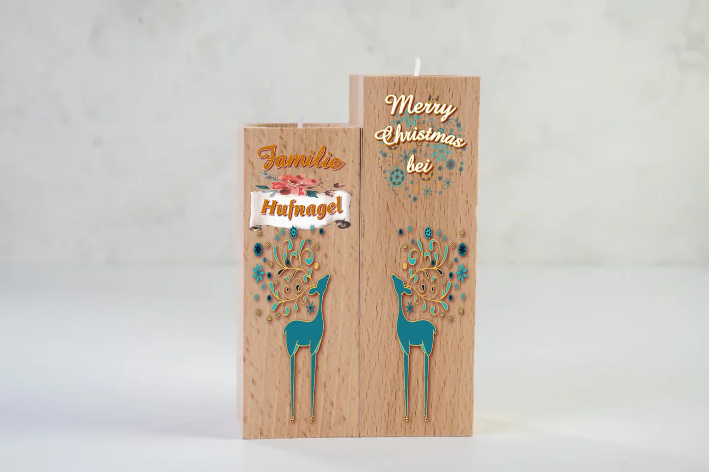 teelichthalter-massiv-holz-2er-set-4,5x4,5cm-12-und-14cm-hoch-personalisiert-mit-familiennamen-weihnachtliches-design-rechter-kerzenhalter-oben-schriftzug-weiss-merry-christmas-auf-leicht-transparente-schneeflocken-und-weihnachtskugeln-darunter-umriss-rentier-in-dezentem-tuerkies-design-kerzenhalter-links-schriftzug-familie-darunter-personalisierter-familienname-auf-schriftrolle-und-ganz-unten-wieder-umriss-rentier-in-dezentem-tuerkies-teelichthalter-auf-neutralem-weissen-hintergrund