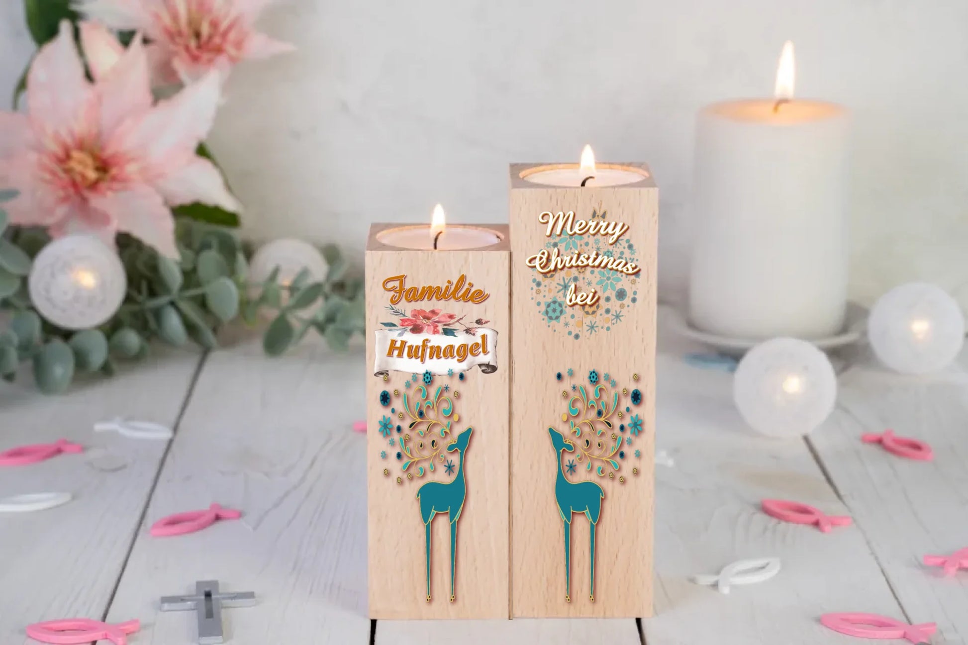 teelichthalter-massiv-holz-2er-set-4,5x4,5cm-12-und-14cm-hoch-weihnachtsgeschenk-nachbarn-personalisiert-mit-familiennamen-weihnachtliches-design-rechter-kerzenhalter-oben-schriftzug-weiss-merry-christmas-auf-leicht-transparente-schneeflocken-und-weihnachtskugeln-darunter-umriss-rentier-in-dezentem-tuerkies-design-kerzenhalter-links-schriftzug-familie-darunter-personalisierter-familienname-auf-schriftrolle-und-ganz-unten-wieder-umriss-rentier-in-dezentem-tuerkis-teelichthalter-stehen-vor-lilien