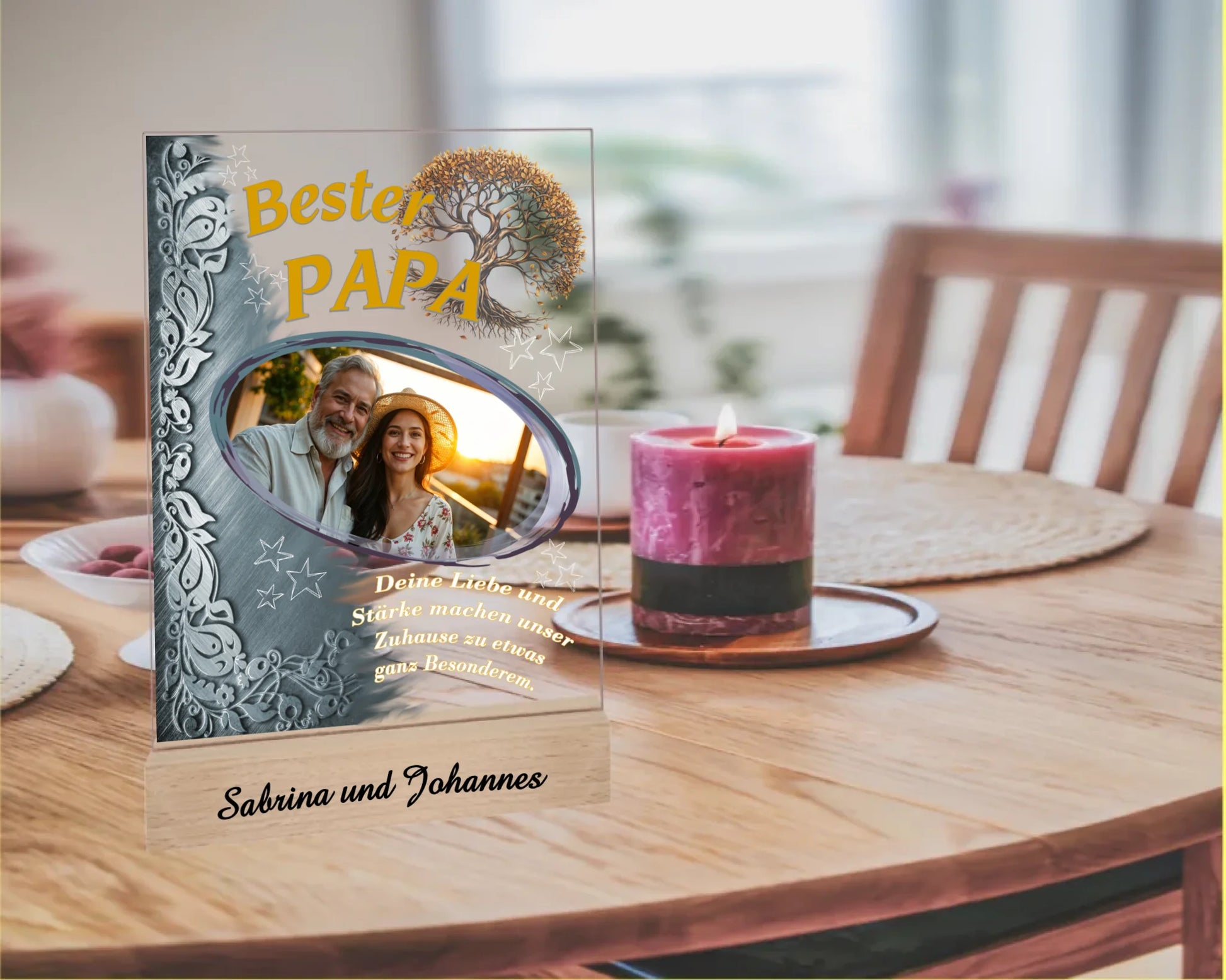 fotoaufsteller-aus-acryl-mit-echtholzsockel-mit-personalisierbaren-foto-silbernen-akzent-auf-der-linken-seite-und-einem-goldgelben-lebensbaum-über-dem-foto-steht-bester-papa-unter-dem-foto-steht-einer-der-fünf-wählbaren-sprüche-der-aufsteller-steht-auf-einem-esszimmertisch-neben-kerze