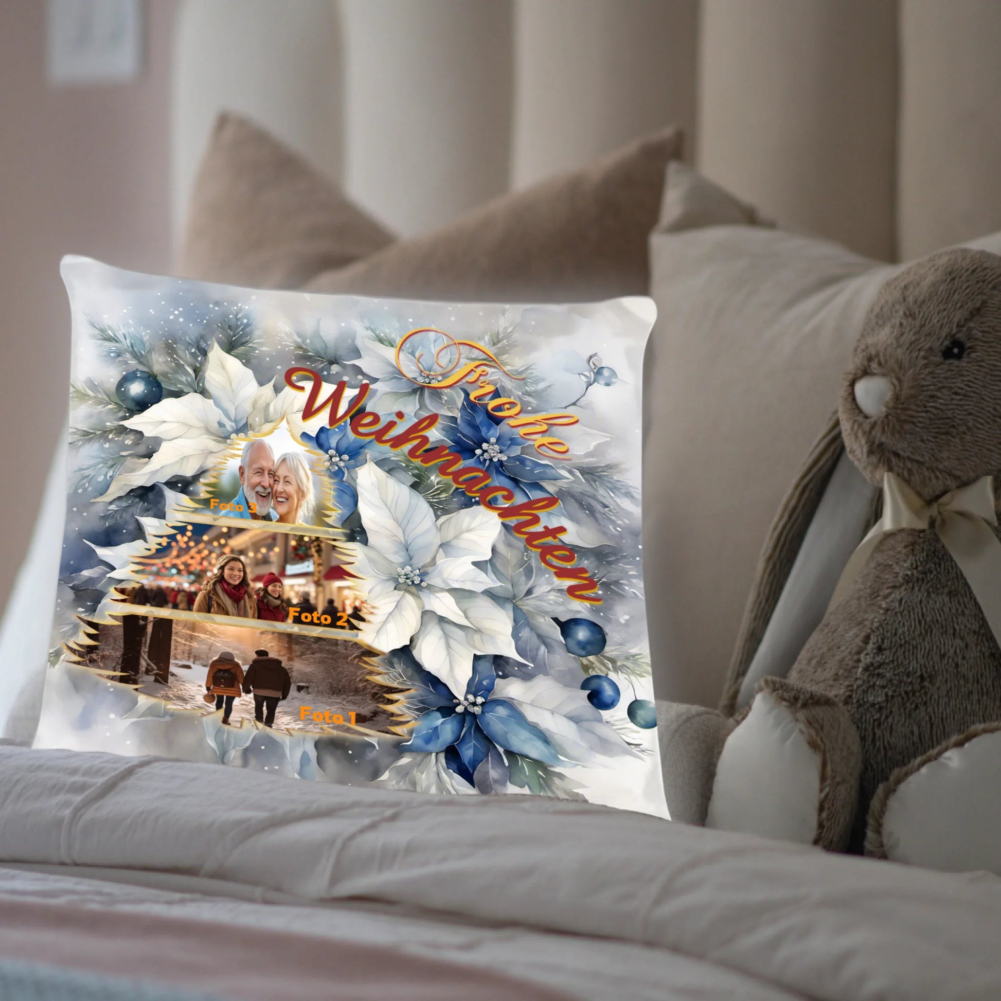 kissen-40x40-cm-mit-foto-collage-vorderseite-mit-collage-mit-drei-eigenen-bildern-in-tannenbaum-form-darueber-schriftzug-frohe-weihnachten-in-gold-gelb-und-weinrot-hintergrund-ist-blume-weihnachtsstern-in-weiss-blau-kissen-steht-in-einem-bett-neben-kuscheltier