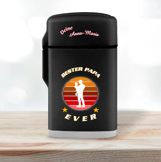 feuerzeug-schwarz-mit-deckel-geschlossen-weihnachtsgeschenk-mit-beschriftung-bester-papa-ever-in-weiß-und-silhouette-vater-mit-kind-auf-dem-arm-feuerzeug-steht-auf-hellem-holz
