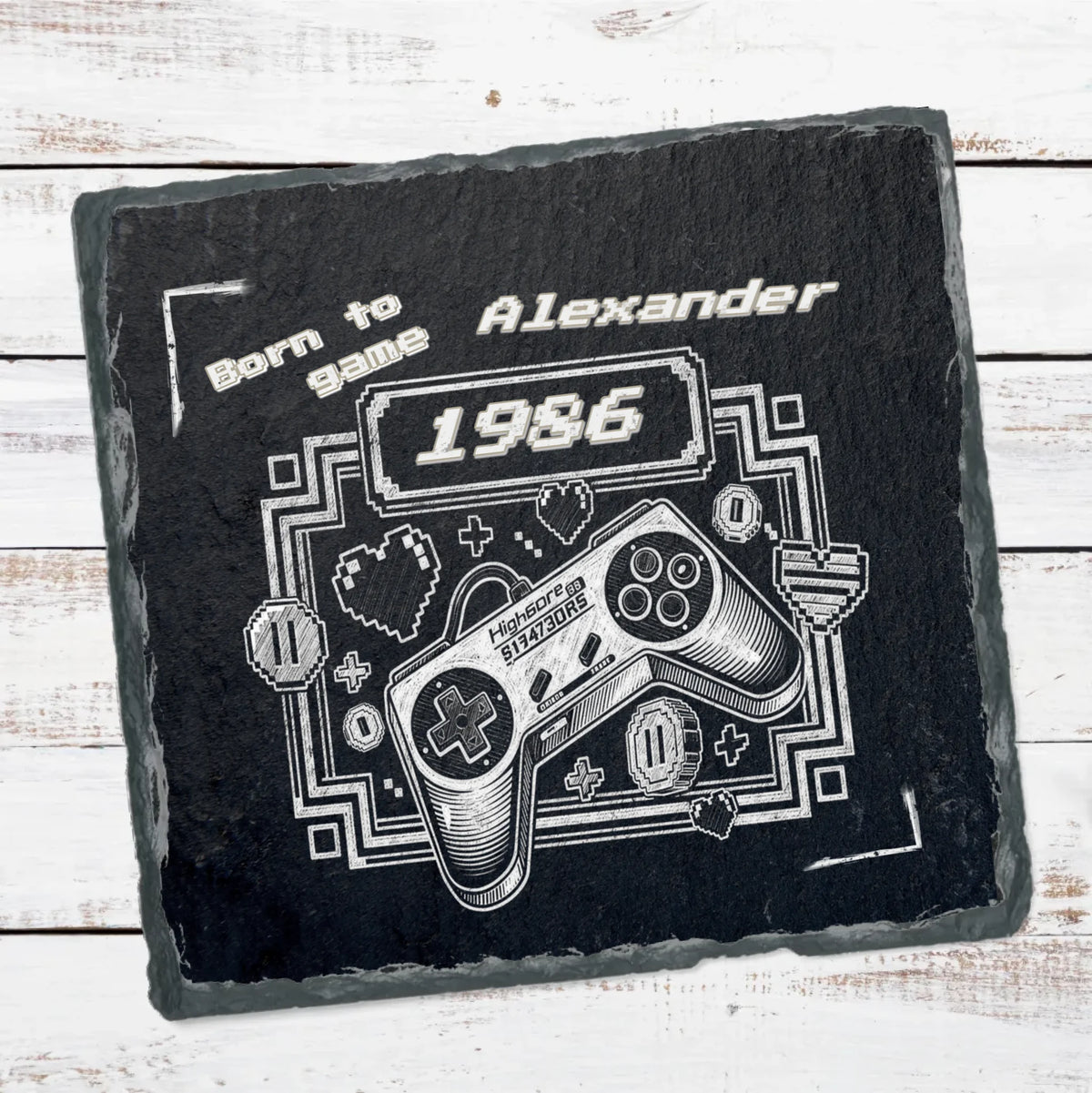 schieferplatte-mit-retro-controller-und-personalisiertem-geburtsjahr-auf-weissen-holzbrettern
