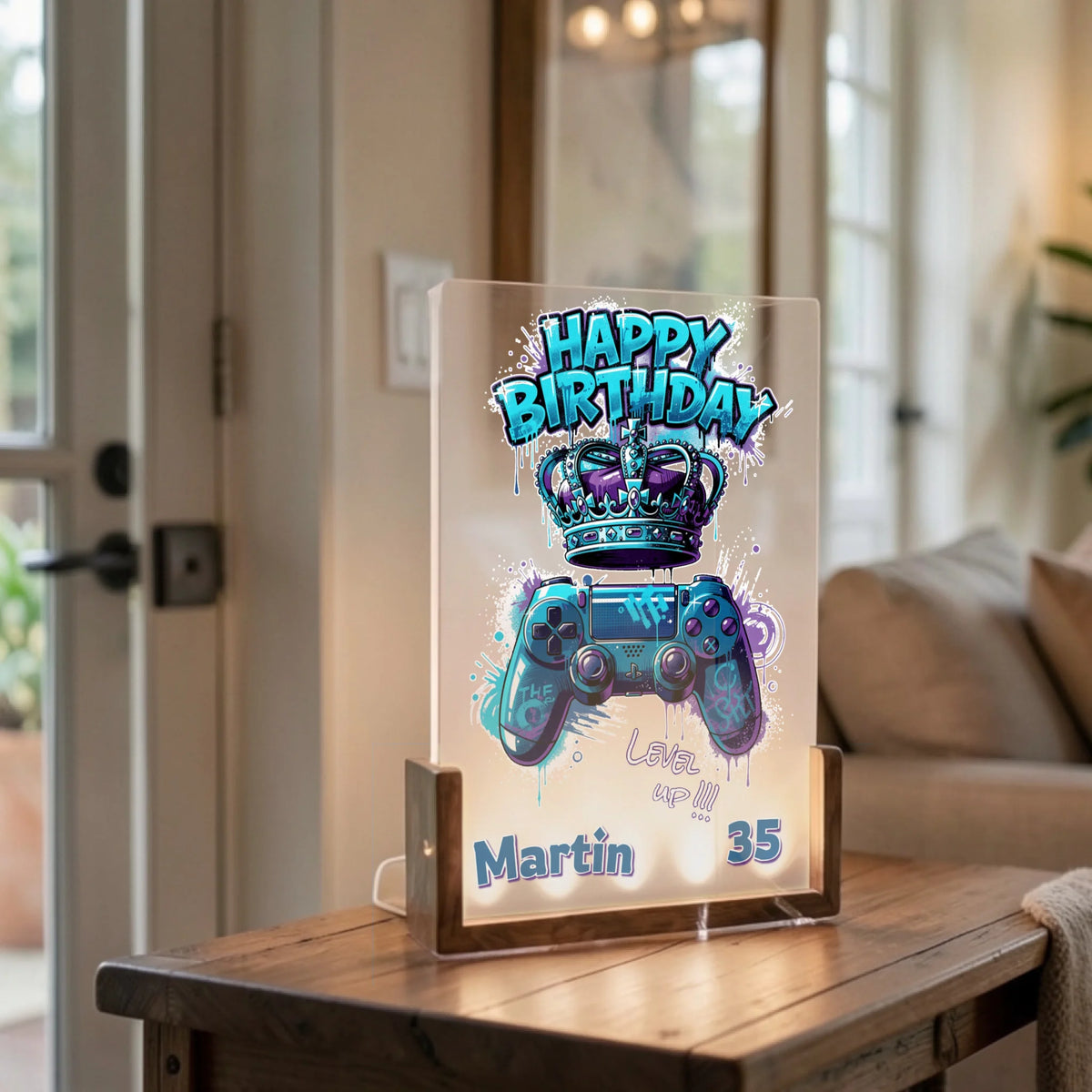 blaue-led-acryl-lampe-mit-happy-birthday-controller-motiv-auf-wohnzimmertisch-mit-sofa-im-hintergrund