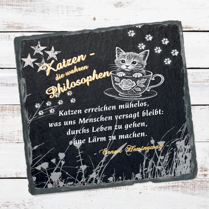 schieferplatte-15x15cm-schwarz-weihnachtsgeschenk-gestaltet-mit-einem-von-sechs-berühmten-zitaten-über-katzen-design-mit-weißem-katzenmotiv-suesse-katze-in-tasse-weisse-pfotenabdruecke-und-sterne-in-den-oberen-ecken