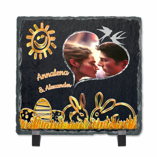 schieferplatte-15x15cm-personalisiert-mit-foto-in-herzform-und-namen-ostermotiv-in-gold-osterhasen-mit-ostereier-und-lachender-sonne