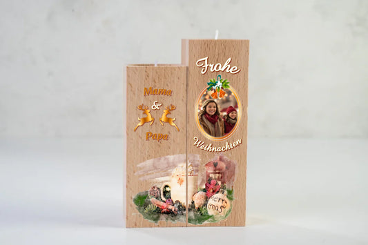 teelichthalter-massiv-holz-2er-set-4,5x4,5cm-12-und-14cm-hoch-personalisiert-mit-foto-und-zwei-namen-weihnachtliches-design-mit-schriftzug-frohe-ueber-dem-foto-mit-ovalem-goldenem-rahmen-darunter-schriftzug-weihnachten-design-kerzenhalter-links-die-beiden-personalisierten-namen-beispiel-mama-papa-in-dunklem-orange-dazwischen-zwei-umrisse-von-rentieren-in-gold-ganz-unten-erstreckt-sich-motiv-weihnachtsgedeck-ueber-beide-kerzenhalter-in-aquqrell-optik-teelichthalter-vor-neutralem-weissen-hintergrund