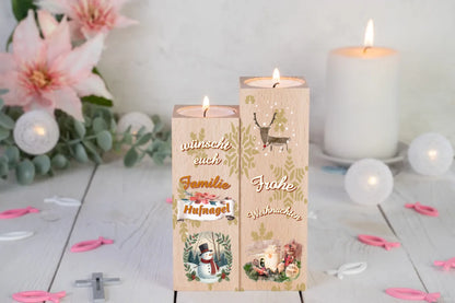 teelichthalter-massiv-holz-2er-set-4,5x4,5cm-12-und-14cm-hoch-personalisiert-mit-familiennamen-weihnachtliches-design-rechter-kerzenhalter-oben-rentier-inmodernem-design-darunter-schriftzug-in-weiss-frohe-weihnachten-ganz-unten-bild-von-weihnachtgedeck-in-aquarell-optik-linker-kerzenhalter-oben-schriftzug-wuenscht-euch-familie-darunter-personalisierter-familienname-auf-schriftrolle-ganz-unten-bild-rund-mit-schneemann-und-zweigen-als-ramen-teelichtalter-steht-vor-lilien-und-weisser-kerze